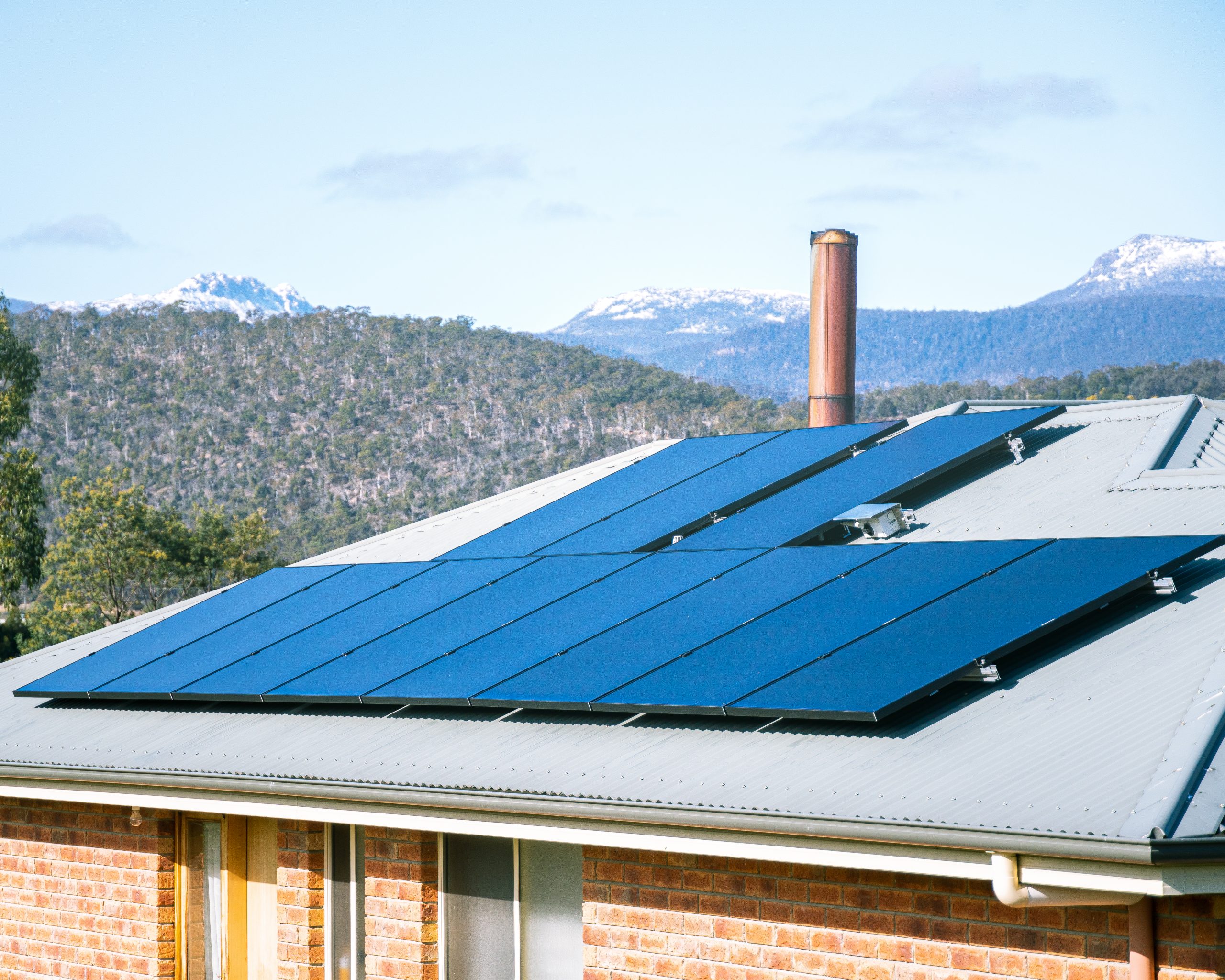 Tasmanian house with multiple roof sections covered in solar panels